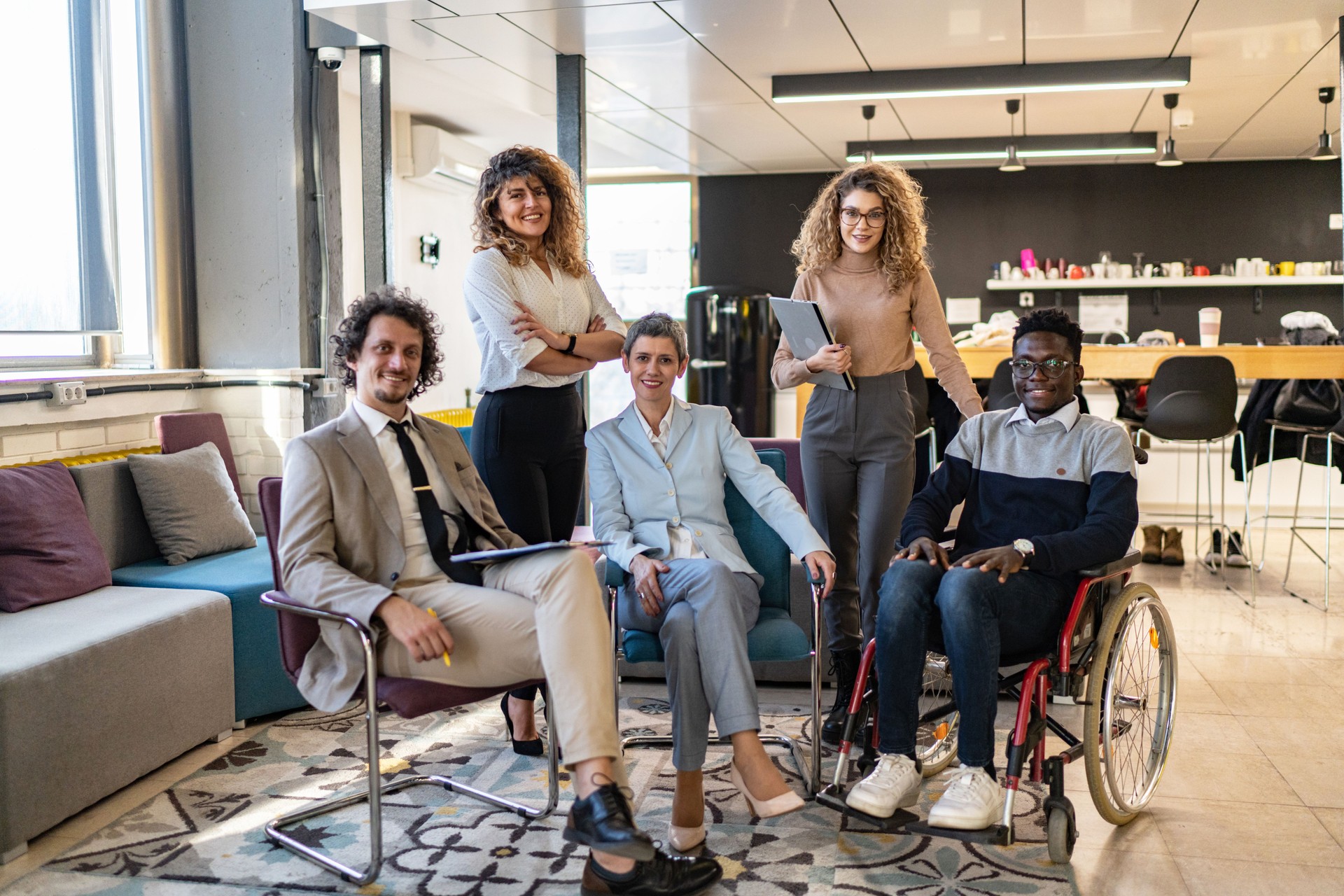 Diverse group of business people, including a businessman in a wheelchair in a modern office